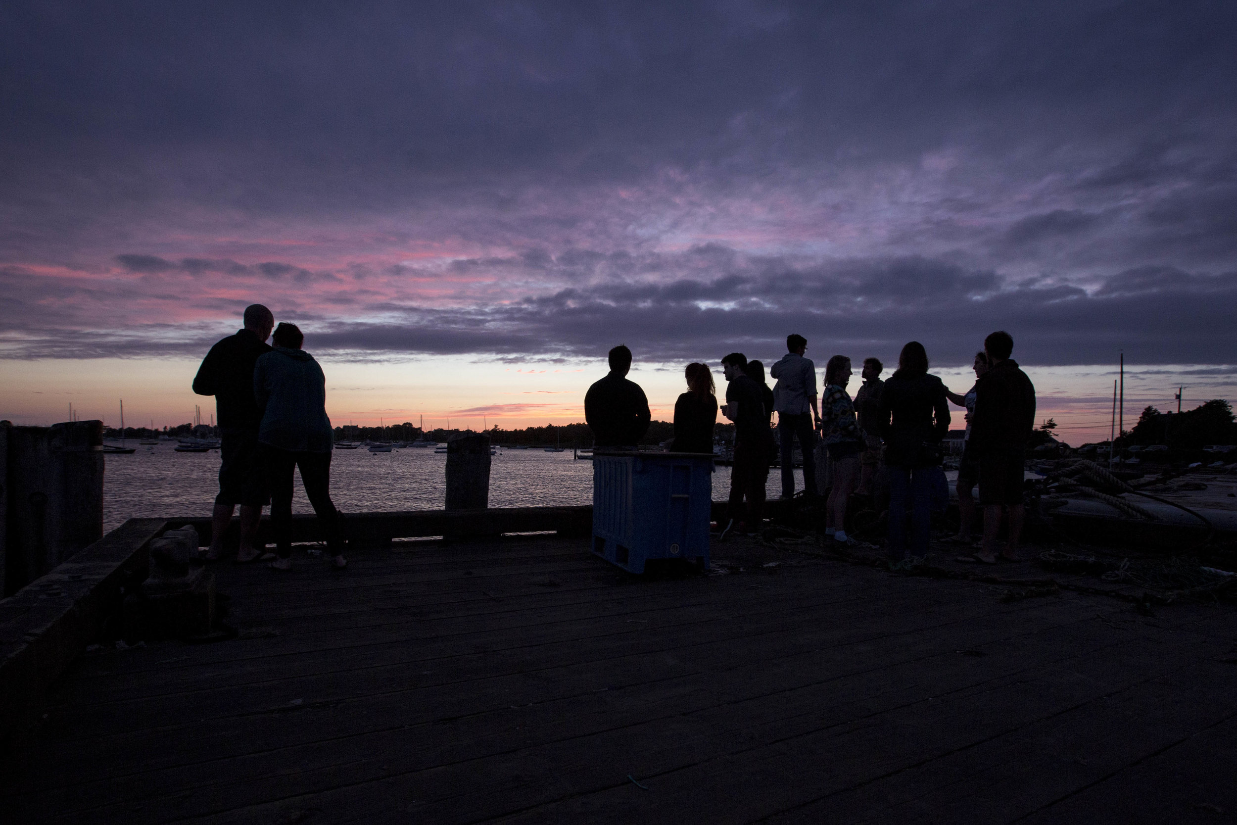  People watch the sunset from the dock by the Woods Hole Science Aquarium on July 29, 2017. 