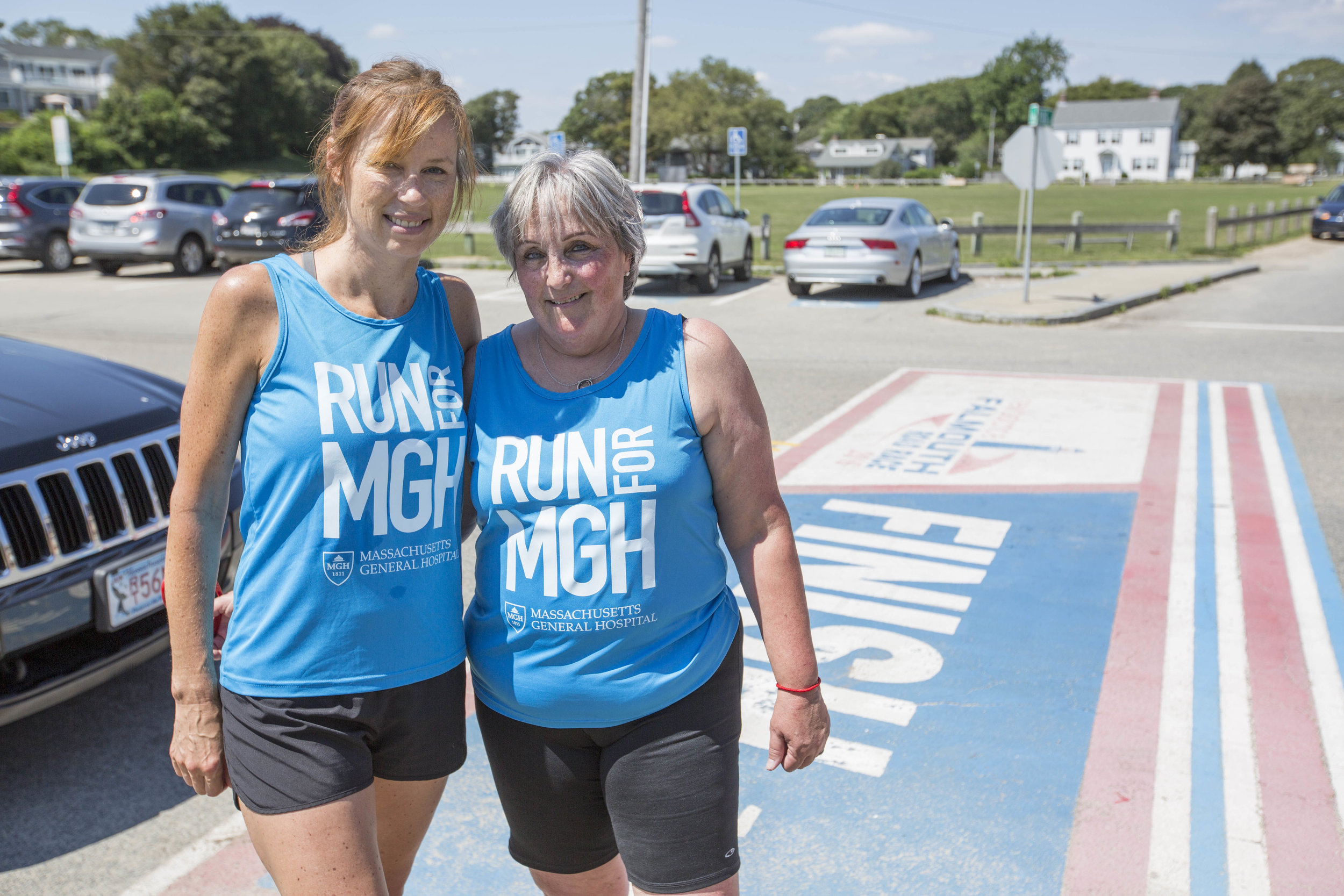  Cancer survivor Suzanne Sarafin and her running partner, Lee Macleod pose for a portrait at the Falmouth Road Race finish line on August 16, 2017. 