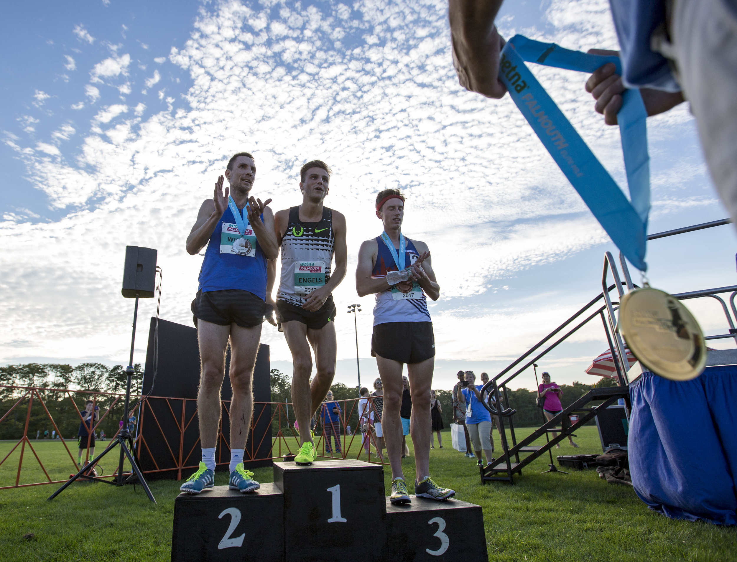  Craig Engels steps up to accept his first place metal next to Nick Willis and Colby Alexander after winning the men's Aetna Falmouth Elite Mile on August 19, 2017. 