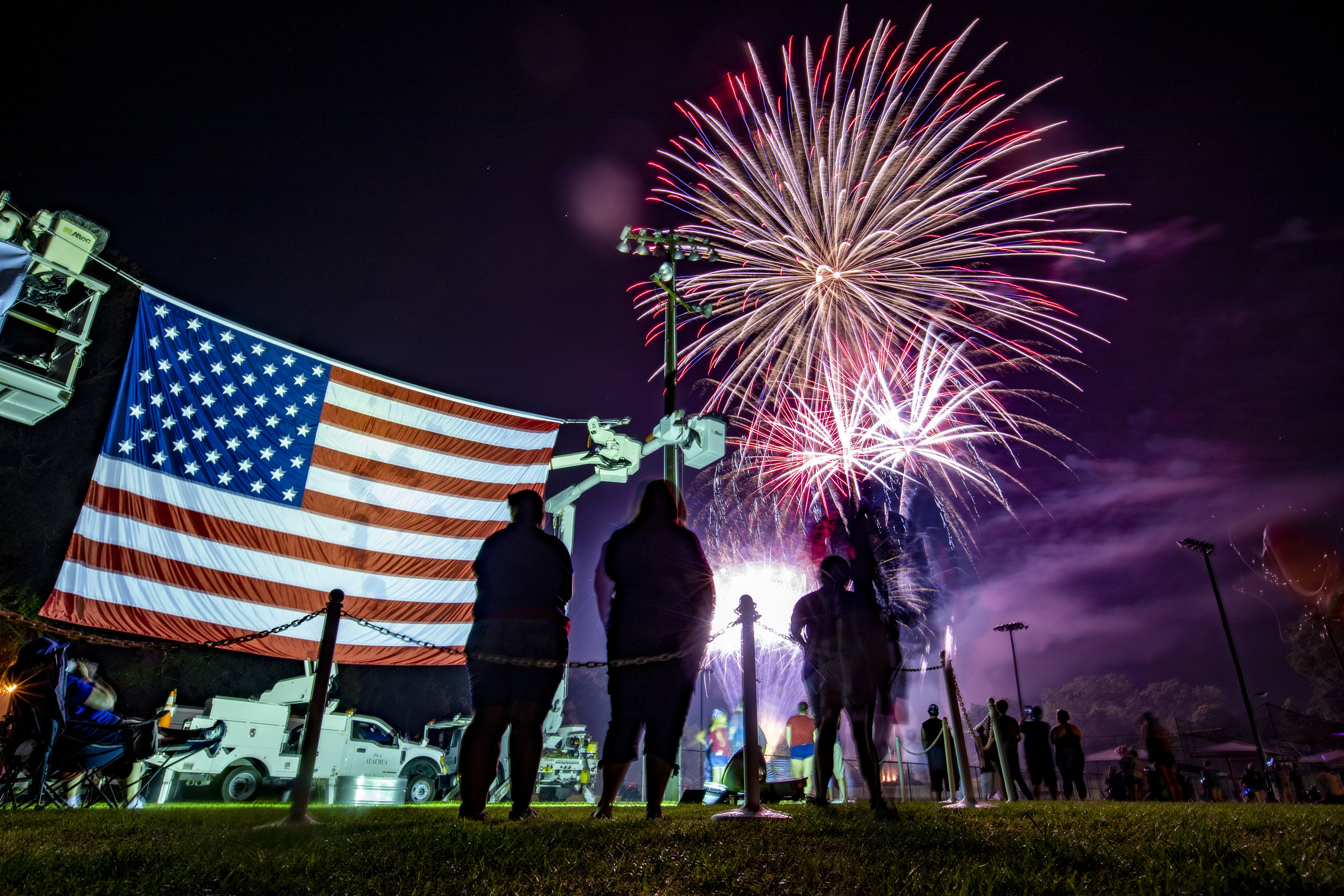  A giant American flag hangs by the stage as people watch fireworks show at the Alachua Fourth of July Celebration at the Hal Brady Recreation Complex on Wednesday. Alachua's firework display has been dubbed the “Largest Small Town Fireworks Display 