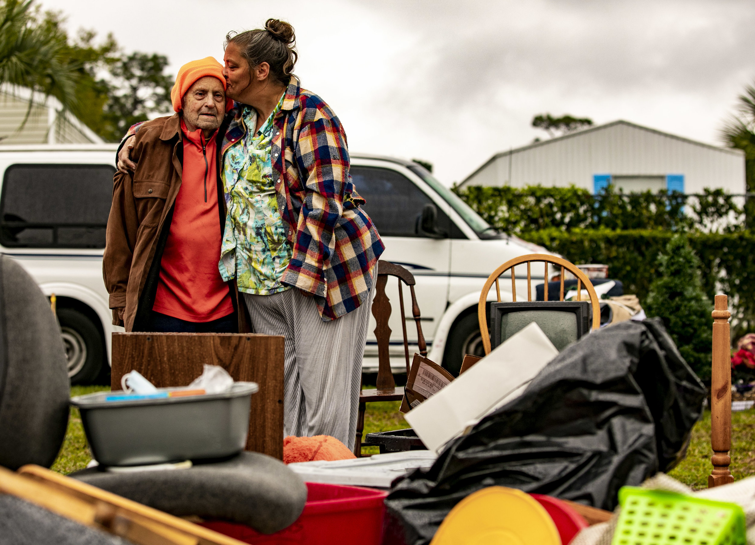  Carie Dineen kisses Robert Noebel as they stand among their belongings in the rain outside of The Palms of Archer on March 5, 2019. Noebel and Dineen were evicted and were attempting to sell their belonging that were strewn across the side of Archer