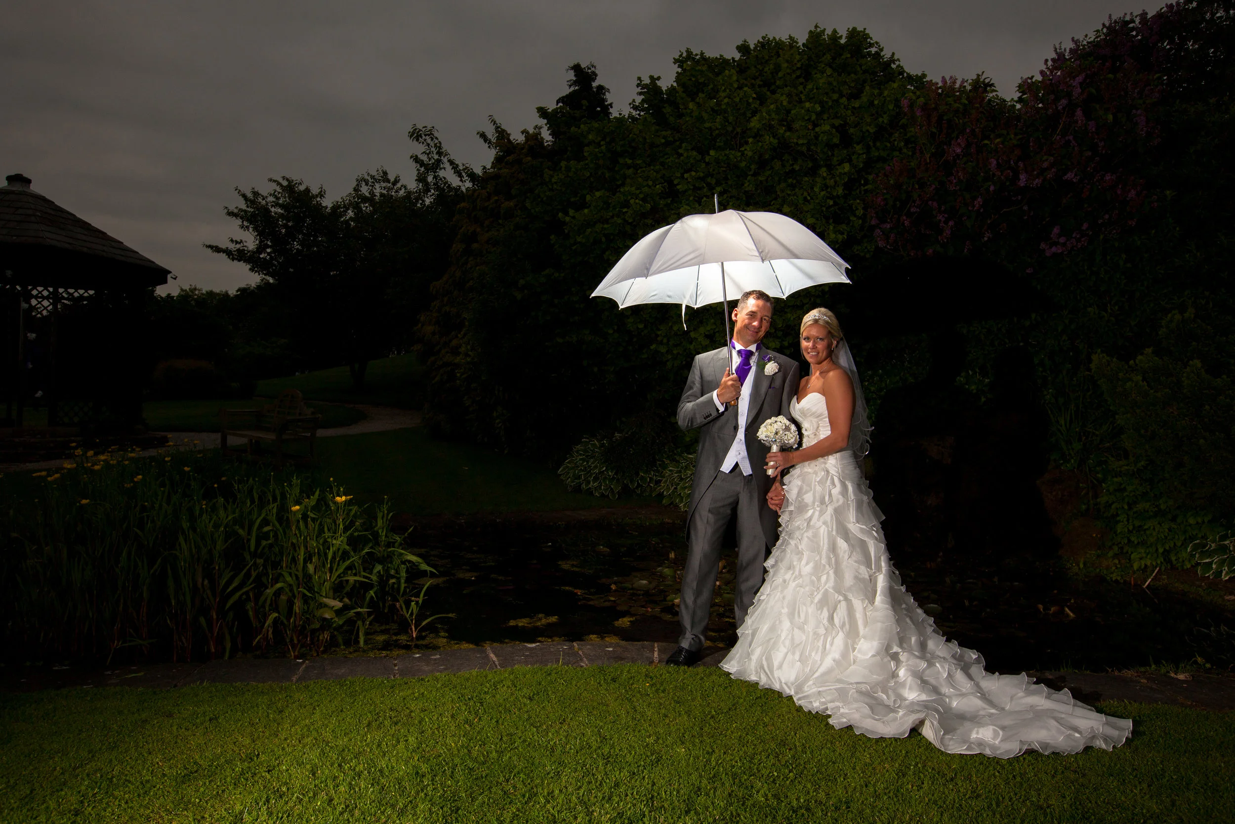 Bride and groom posing with umbrella /affordable wedding photography Lancashire,best wedding photographers  Lancashire,natural wedding photographer