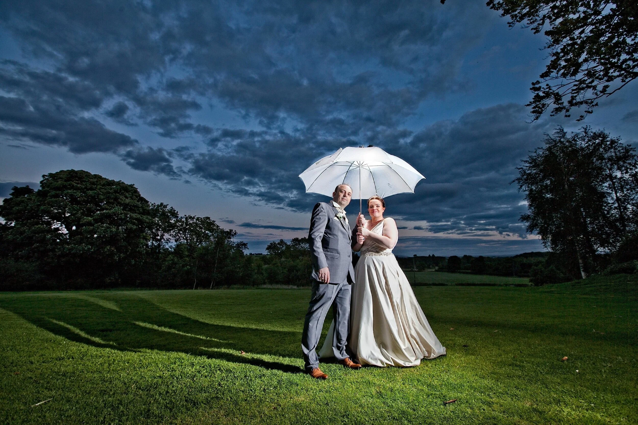 Bride and groom on their wedding day posing  for umbrella  photo