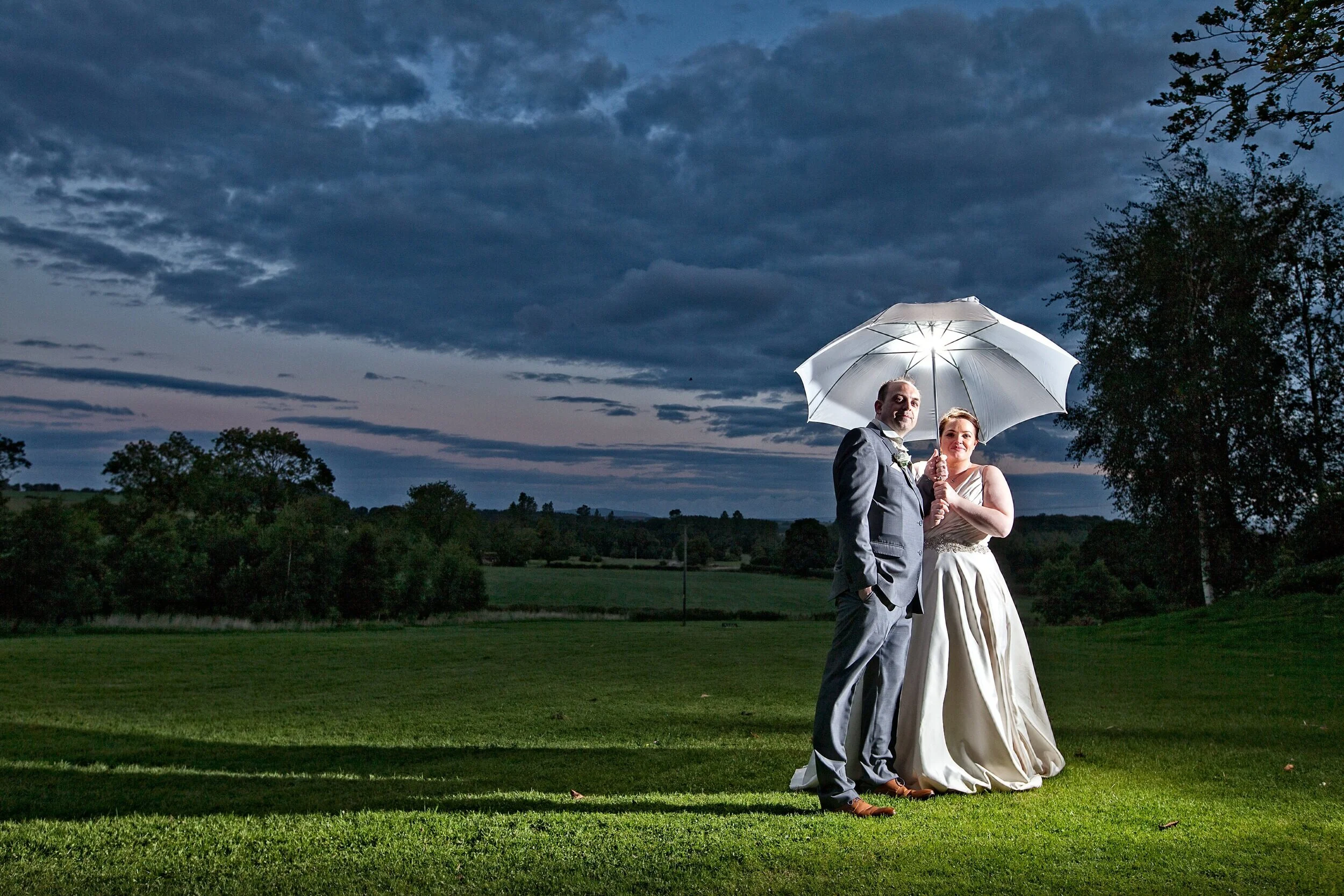 Bride and Groom at sunset /Newlyweds pose for umbrella shot at The Stirk House Hotel,Lancashire .#best wedding photography in Lancashire