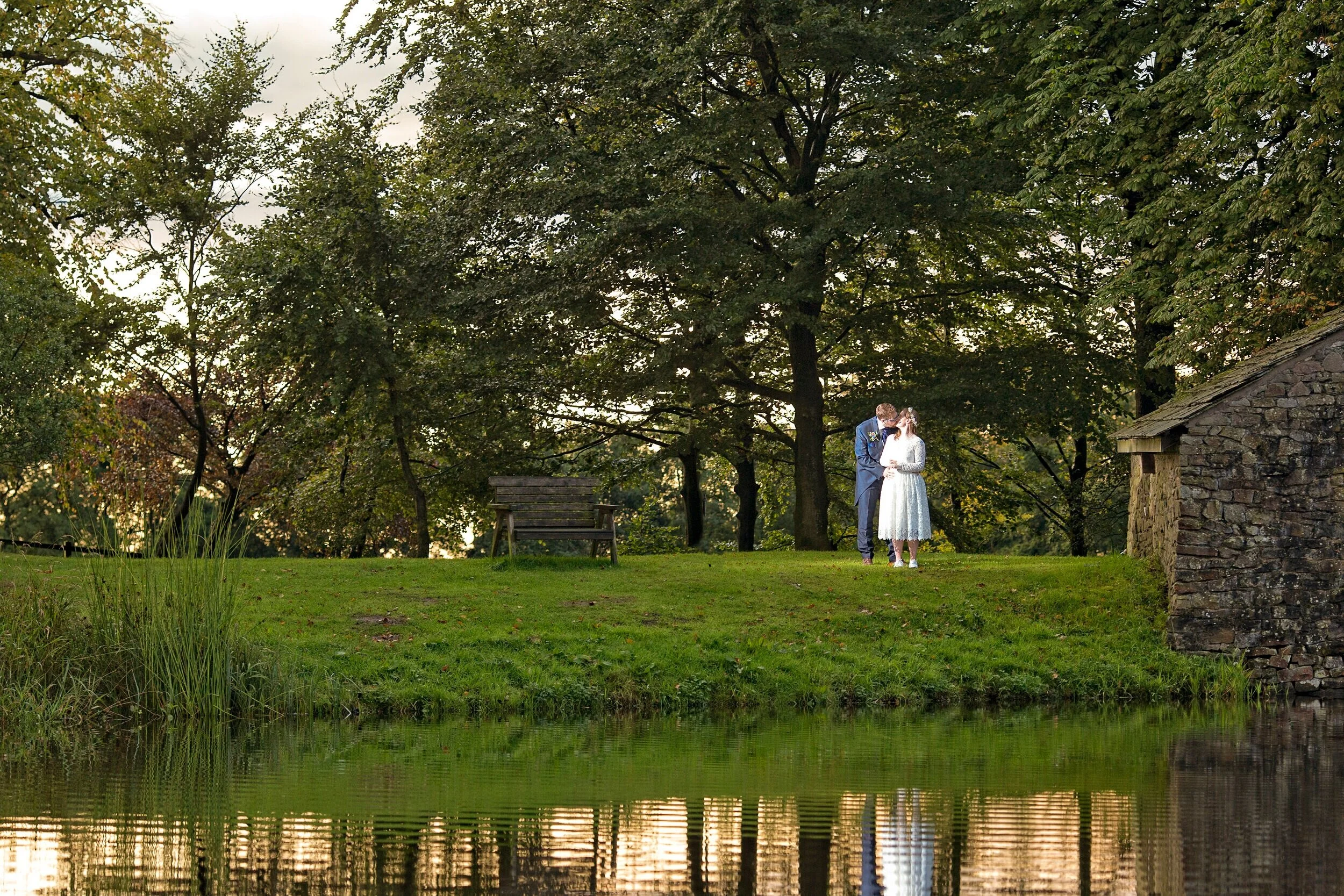 Matt and Fran stand by lake at The Tithe Barn in Trough of Bowland,Lancashire.Images by Avanti #photography in Lancashire #high class wedding photography