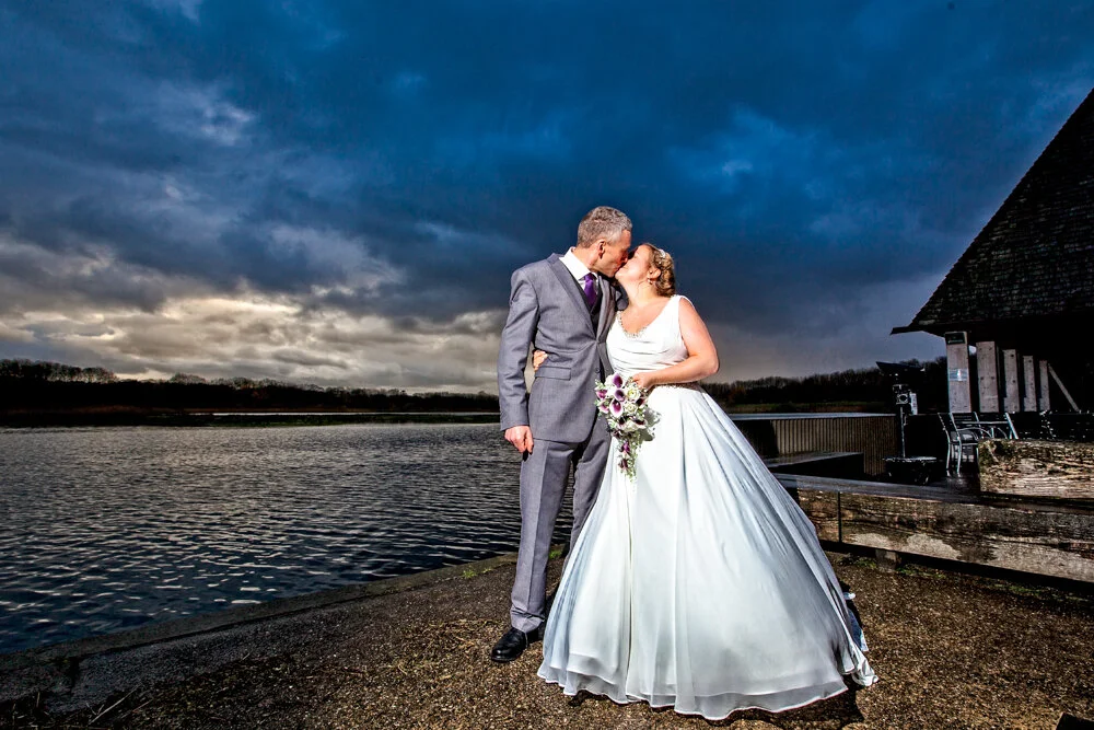 Bride and Groom at the Brockholes Nature reserve posing between showers.