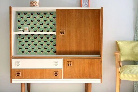 Mueble estilo años 50 con detalles pintados en blanco y fondo en papel. Imagen Pinterest
