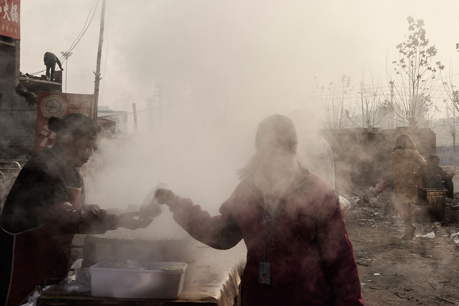 A female Foxconn worker, buying a steam bun on her way back to her room at the end of the night shift.