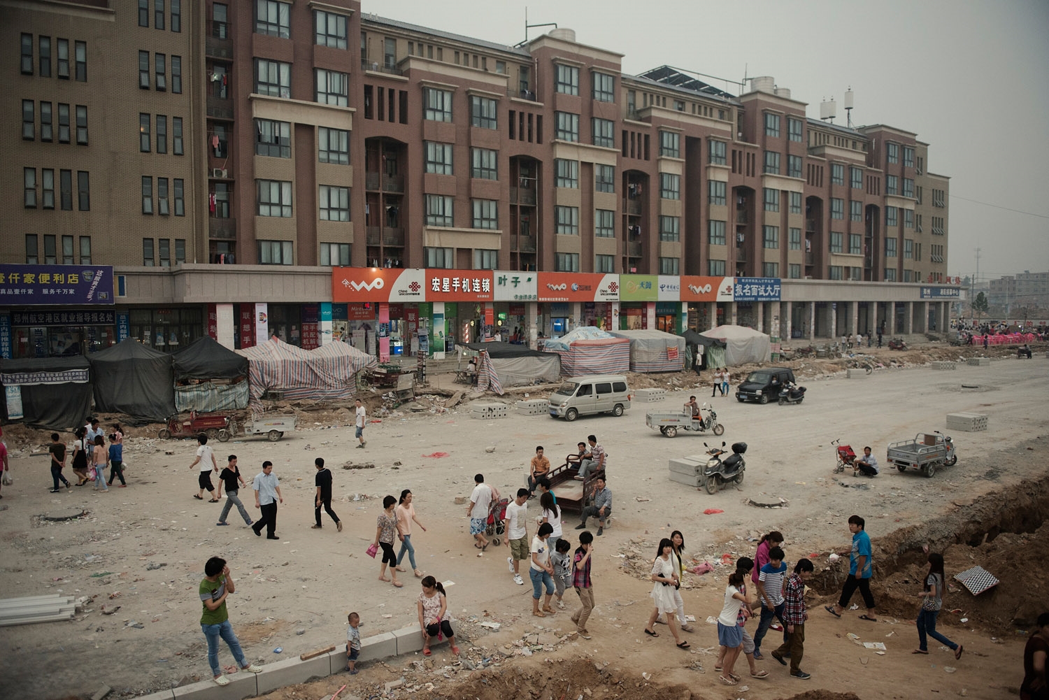 Foxconn dorms on a street still under construction.In the span of two years what were rural villages on the outskirt of Zhengzhou has become a bustling factory city dedicated to Foxcoon, and housing 200 000 workers. The city is still expanding with new factories being built.