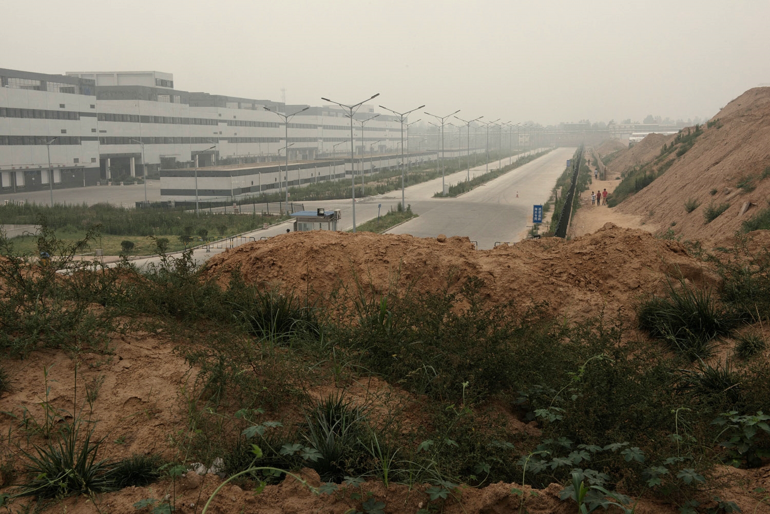 A Foxconn plant on the oustkirts of Zhengzhou. In the span of two years what was a group of rural villages has been transformed into a factory town with over 200 000 people mainly working at the production of Iphones. Foxconn, a Taiwanese company, is one of Apple main subcontractors and employs over 1.2 million people including hundreds of thousands in China. 