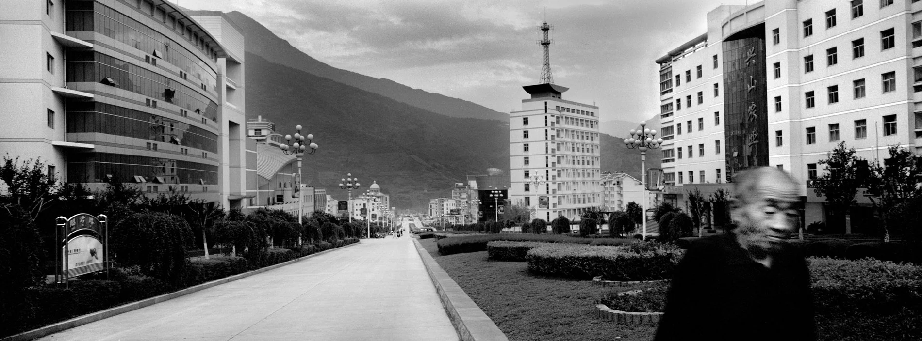 A passer-by in the empty streets of Gaoyang. Positionned by a subsidiary of the Yangtze, the old city will be flooded in the summer of 2006. The new city has been rebuilt 30 kilometers away, but economic activity has yet to follow. So far mainly civil servants live here. Businesses are reluctant to settle due to the remote location of the new city.