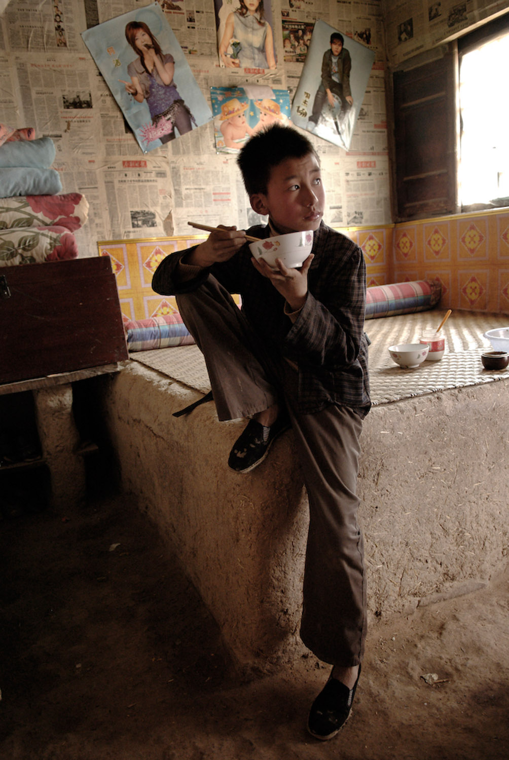   Liu Wei, an orphan, eating a bowl of noodles at his grandma's who struggles to support him.  