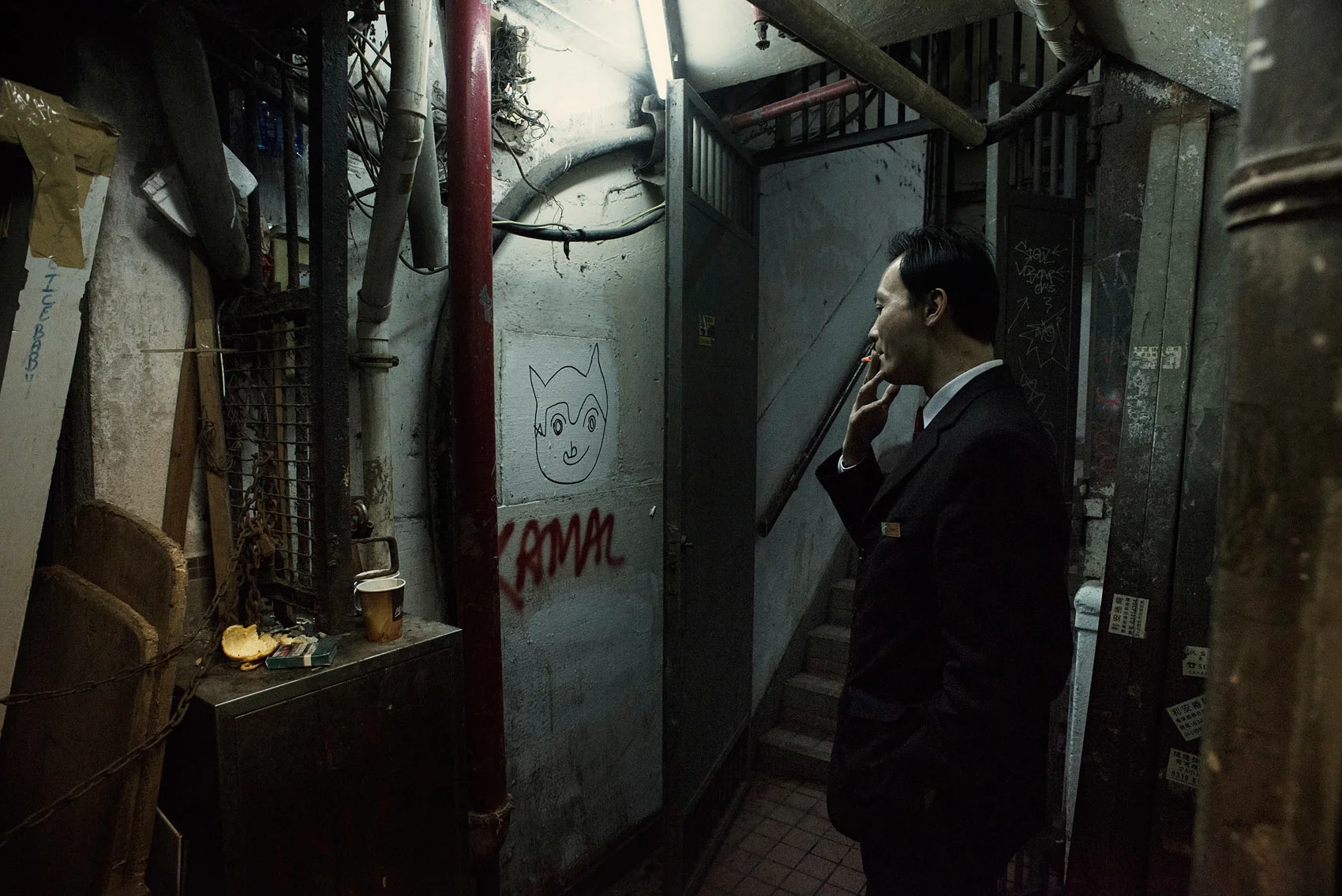 In a back alley of the Chungking Mansions, the staff of department store is taking a cigarette break.