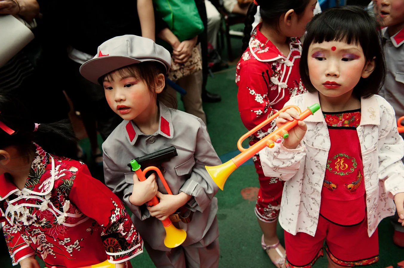 At Dadi kindergarten in Chongqing, children before a show for Children's day. One of them dressed up as a PLA soldiers is holding a plastic gun. The show includes a revolutionary piece: the story of Wang Erxiao a kid who sacrifices himself to lead the 8 route army to victory against the Japanese. 