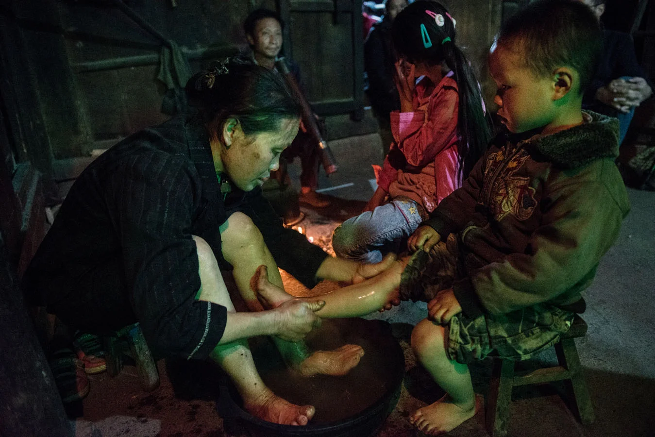 Tian Mei's 3 years old little brother is having his feet washed by his grand mother from a water basin, a nightly ritual in the yan family. The house has no running water and it has to be brought from the pond. The Yan grand parents have to take care of their for grand children. 