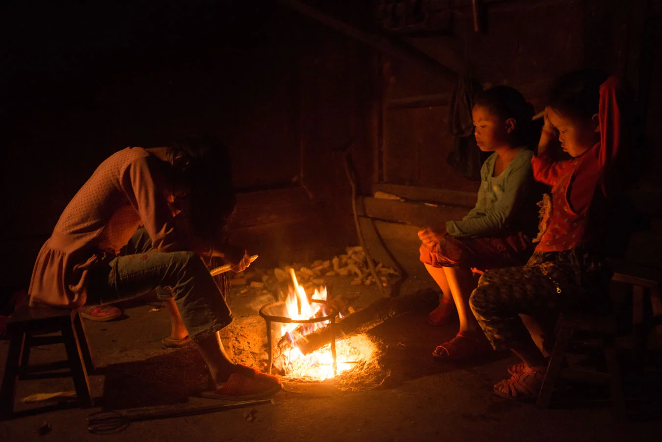 At 5 am, Tian Mei and her sisters are up, sitting by the fire they have started. Tian Mei is combing and drying her hair.