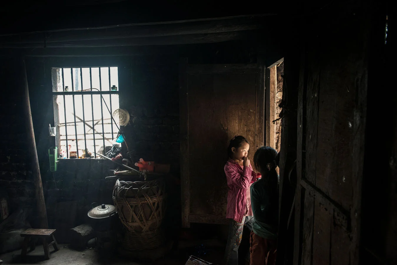 11 years old Yang Tian Mei, standing by the door of the kitchen with one of her sisters, at her grand parents' home. 