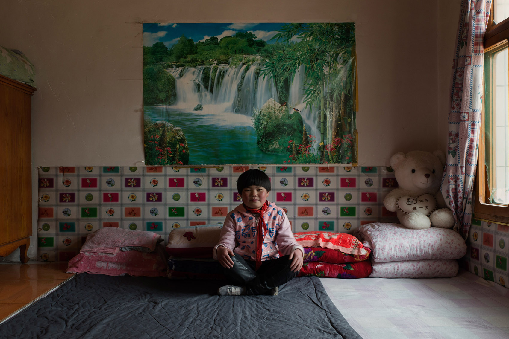 Gupo village 12 years old He Tiantian on the kang she shares with her aunt who is raising her. Her mother died in an accident when she was 5 and her father has not been heard of after he left the village to find some work the same year. She wants to be a dancer.