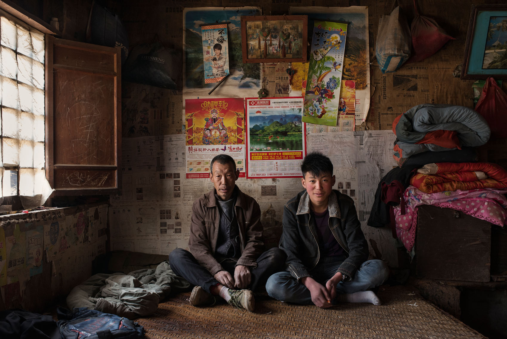 Xincheng Village Fu Wenbin (15) on the kang he shares with his dad Fu Decang, (50) Wenbin was mostly brought up by his grandmother, as his father spent 5 years in prison. The grandma passed away when he came out, two years ago. Wenbin will be entering middle school next year and would like to go on to high school if he can, but his father wants him to find a job.