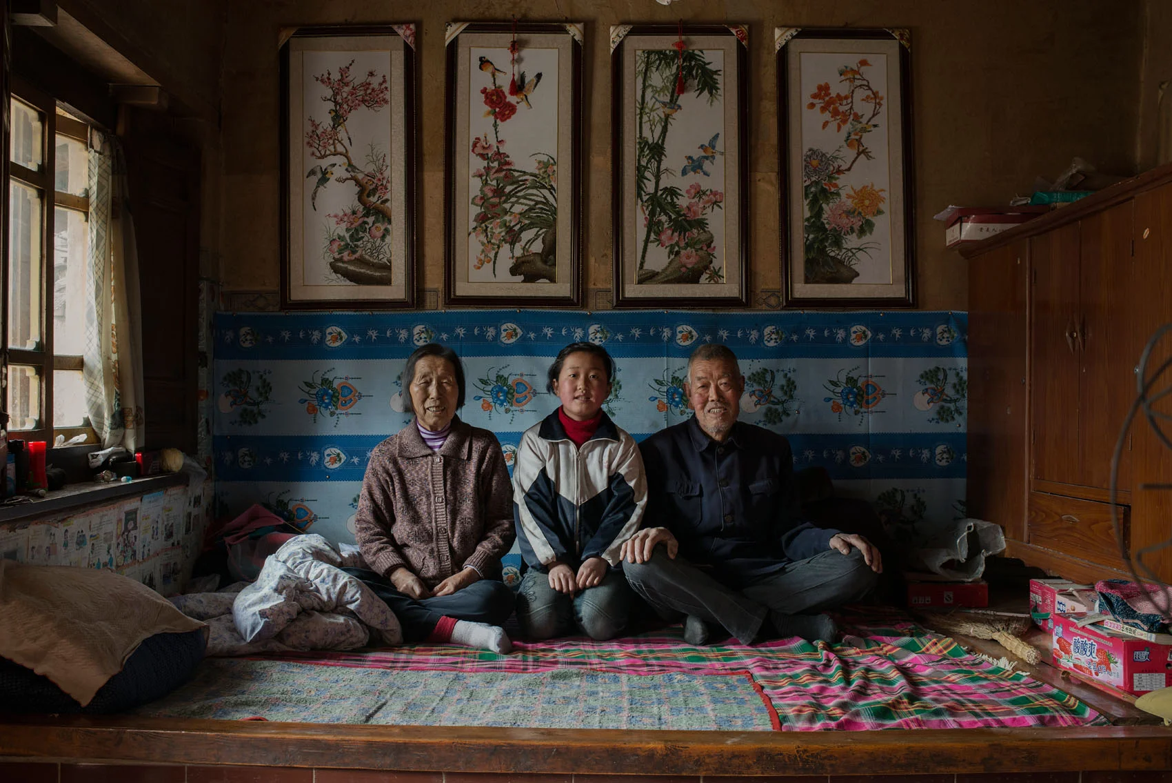  12 years old Xie Hong with her grandparents who are taking care of her. Hong's mum left her after the death of her father (often widows don't stay with in-laws in poor rural China, even at the cost of leaving the children behind). Hong's grandparent