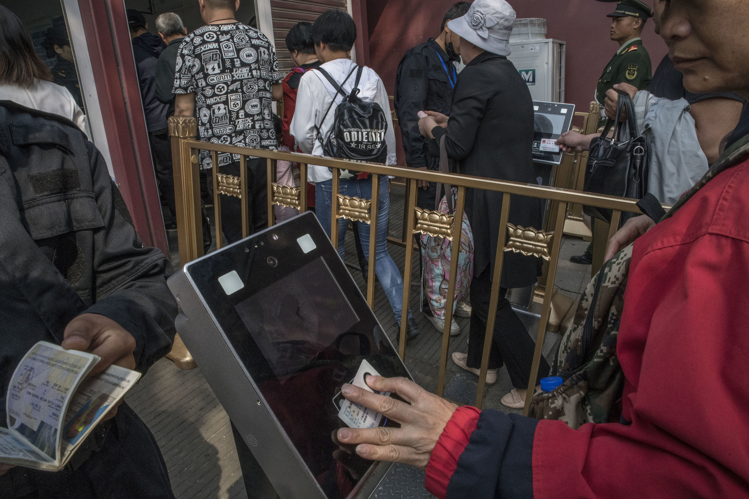 Visitors to Tian An Men square having their ID scanned at a security check. The machines are equipped with cameras for facial recognition.