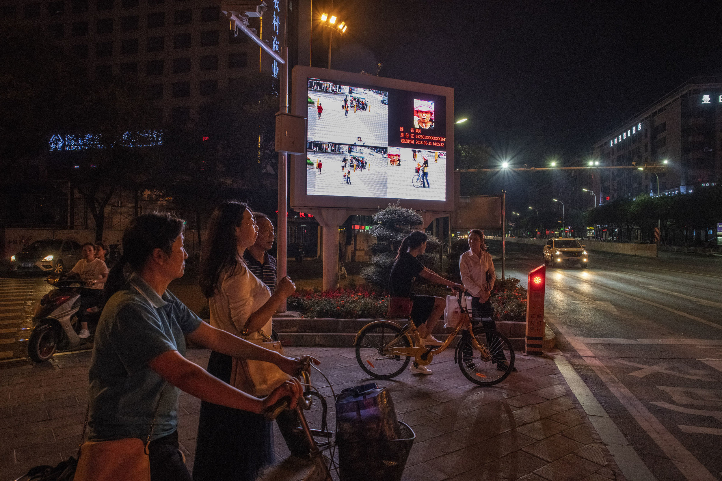 In Xiangyang, at a crossroad equipped with monitoring cameras linked to facial recognition technology, an outdoor screen displays photos of jaywalkers alongside their name and I.D. number. The idea is to embarrass offenders into compliance.