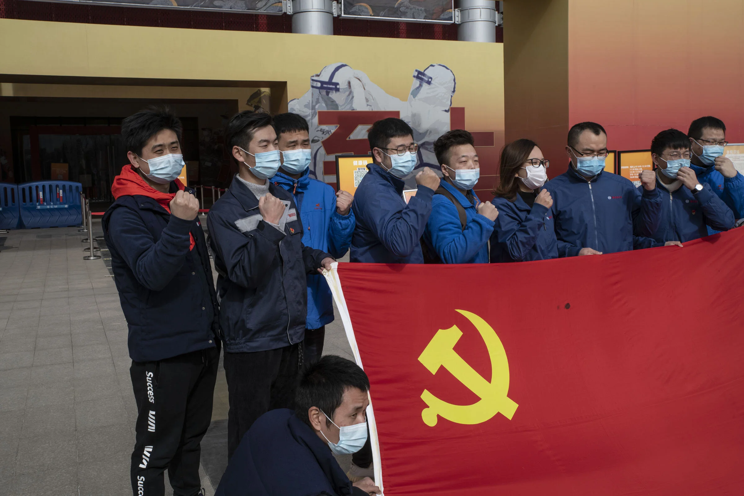 A Communist Party cell of the German manufacturer Bosch poses for a souvenir picture in front of the exhibition hall where they just visited an exhibition about the fight against Covid. The Communist Party of China has taken much credit for the succ