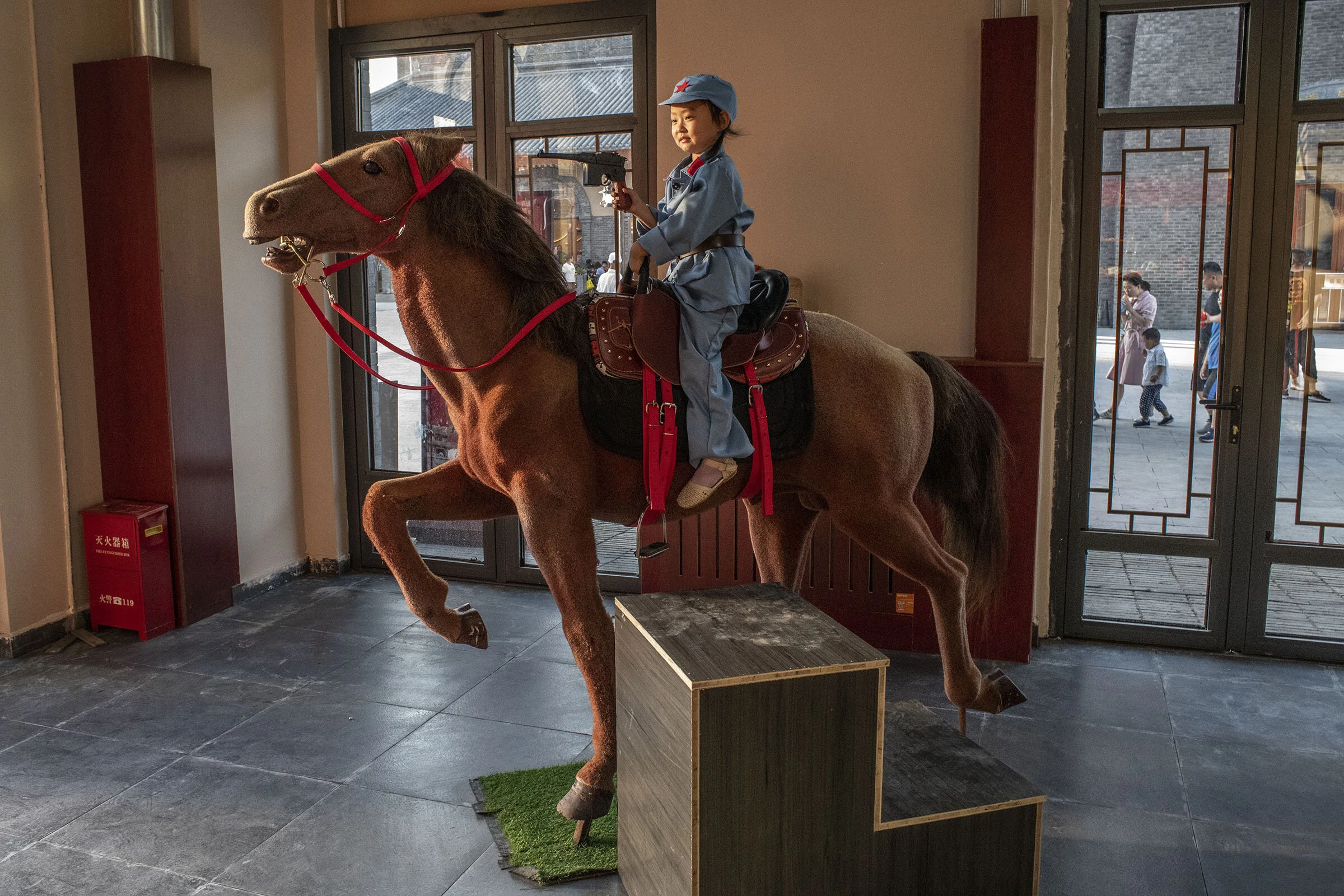 At a photo studio of the newly opened Wanda red themed entertainment park in Yan’an a young girl posing as a red army soldier.
