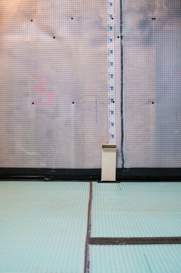 Plastic membrane wraps all the floor and walls of the new space. The floor will shortly be filled with sand and concrete to create a new solid surface