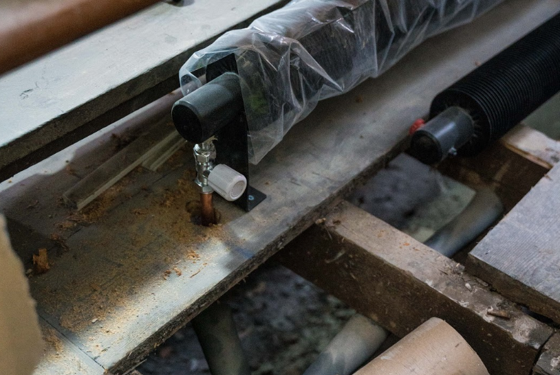 Sealed radiators in the process of being installed under each of the pews.