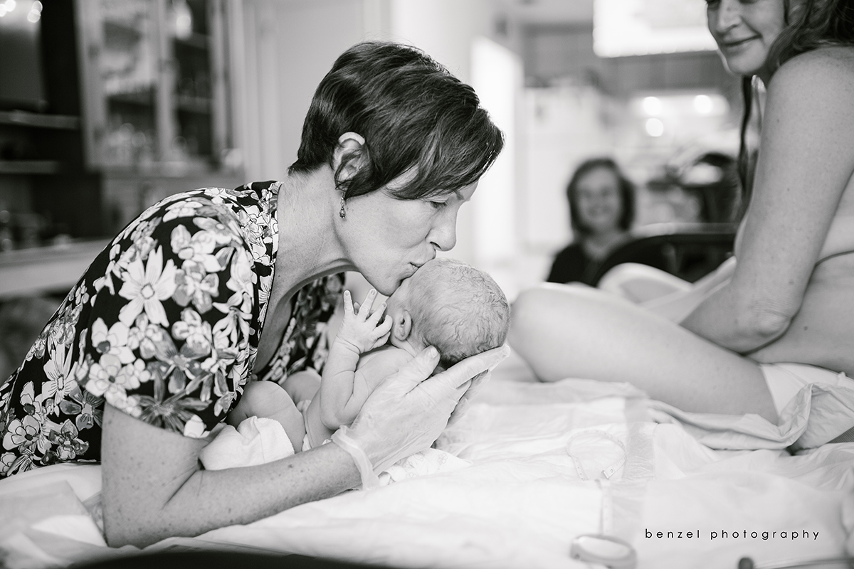 Midwife kisses baby