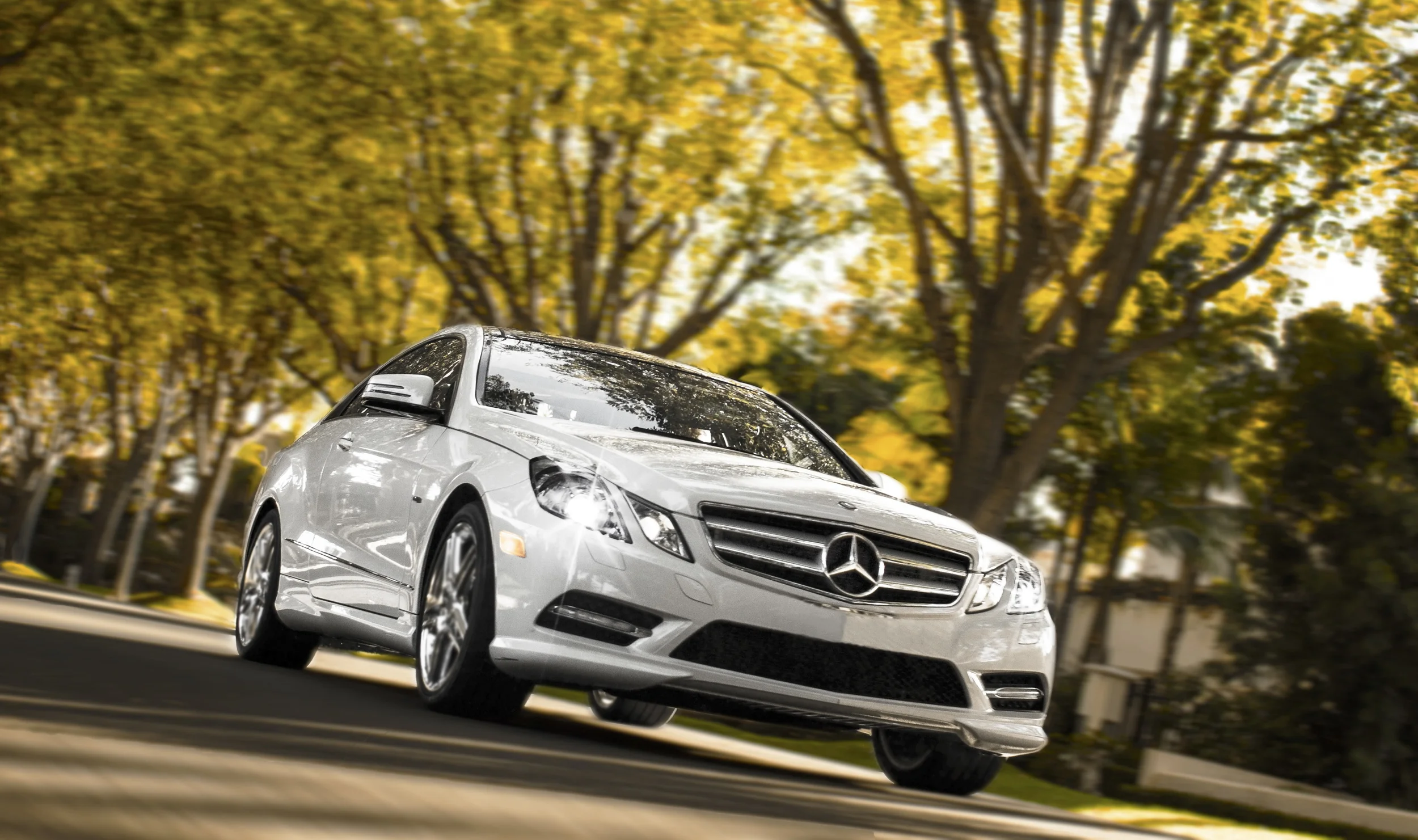 Location. Location. Location. Automotive photography is all about location. To create an autumn-look for an upcoming promo, we found an amazing tree tunnel in Beverly Hills with bright yellow/green leaves. Attaching a carbon fiber extension off the Mercedes' frame, we were able to capture a long-exposure image, blurring the background, and still keeping the vehicle in sharp focus. Bits of Photoshop are also used to freeze the rims to reduce motion blur. Another bonus of shooting inside tree tunnels: The lining of trees creates a blanket of soft light, the time of day is irrelevant. That means no more waiting 'til Magic Hour...go get yourself a cold one instead. 