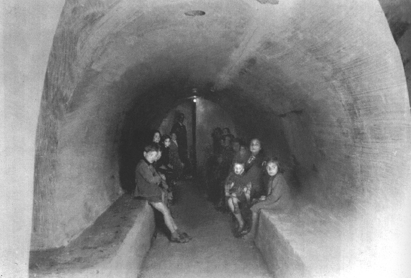Families huddle in a bomb shelter under Naples during World War II. Image Credit: Photographic History of Naples, edited by Gloria Chianese, published by Intra Moenia