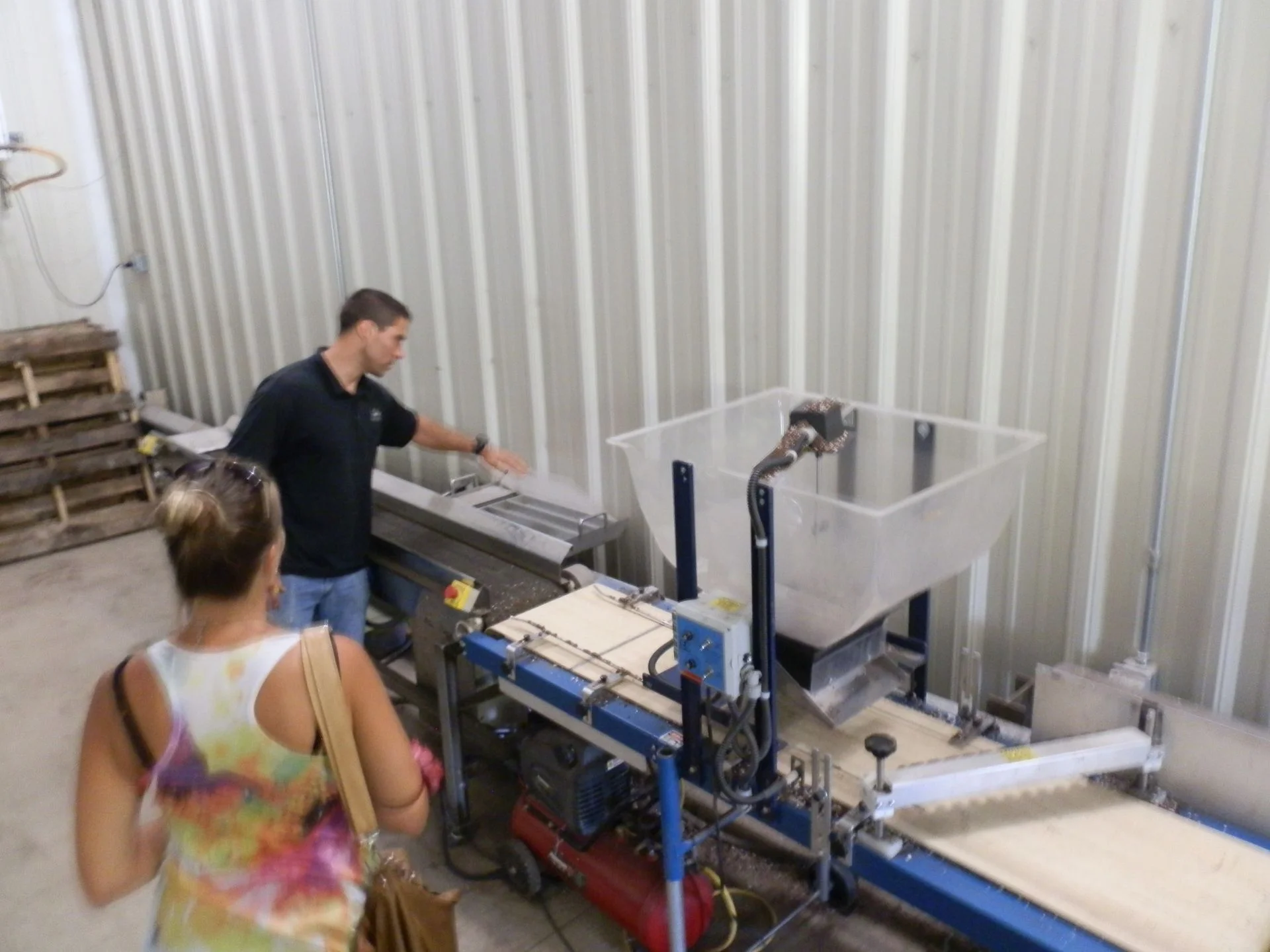 Andy explains the automatic seeding machine, engineered by an "Amish genius", ensuing even micro green seed distribution