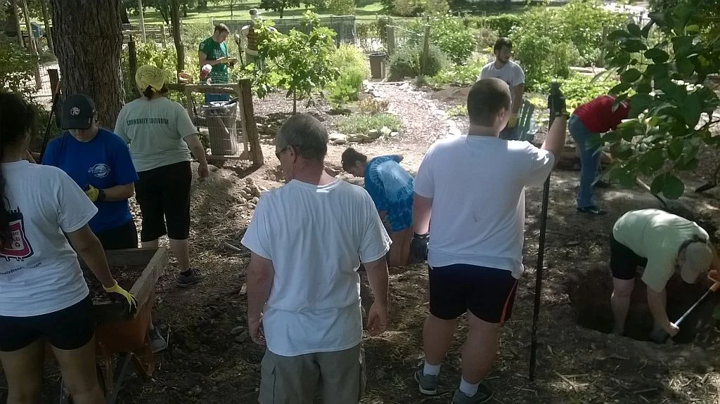 Volunteers and students dig foundation for harvest house