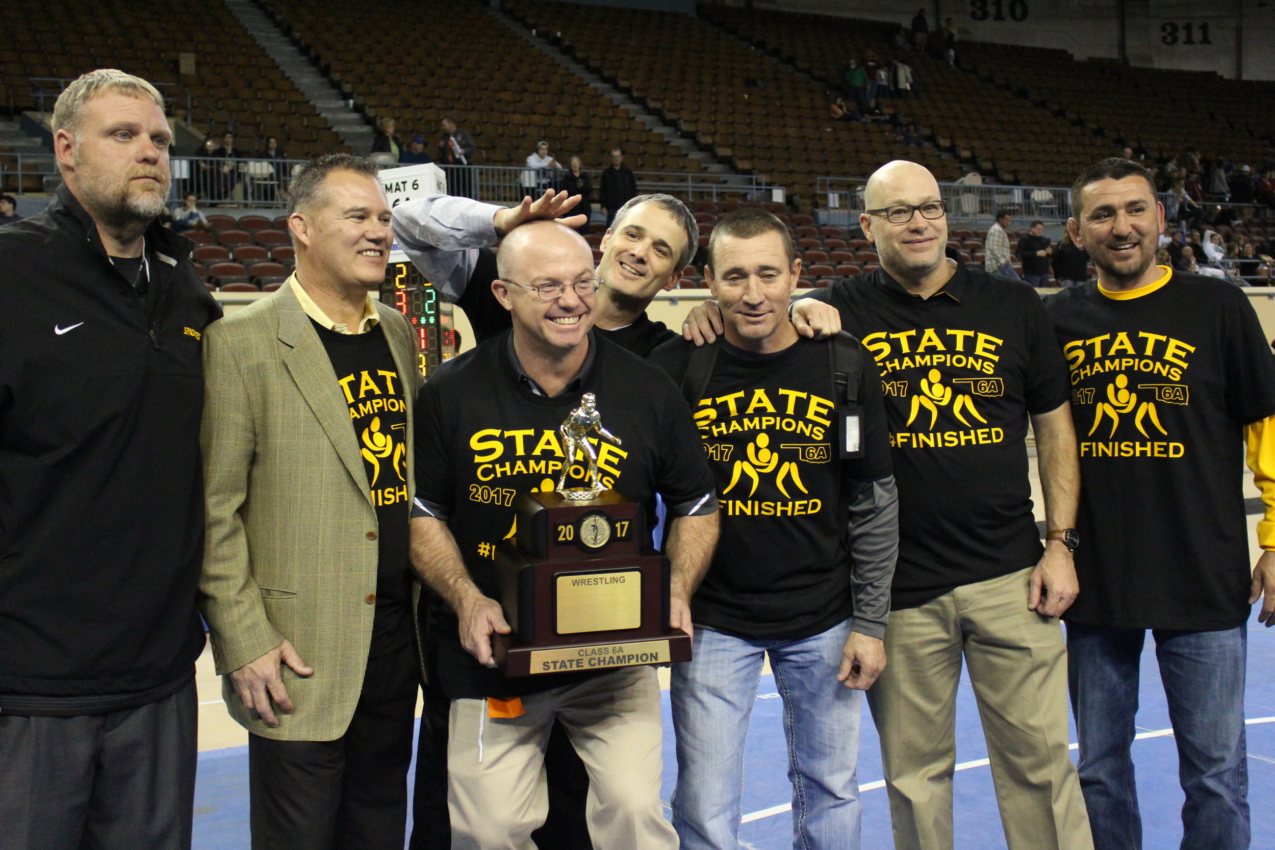  The Charles Page High School wrestling coaching staff poses with their 2017 State Tournament Championship trophy. (Scott Emigh). 