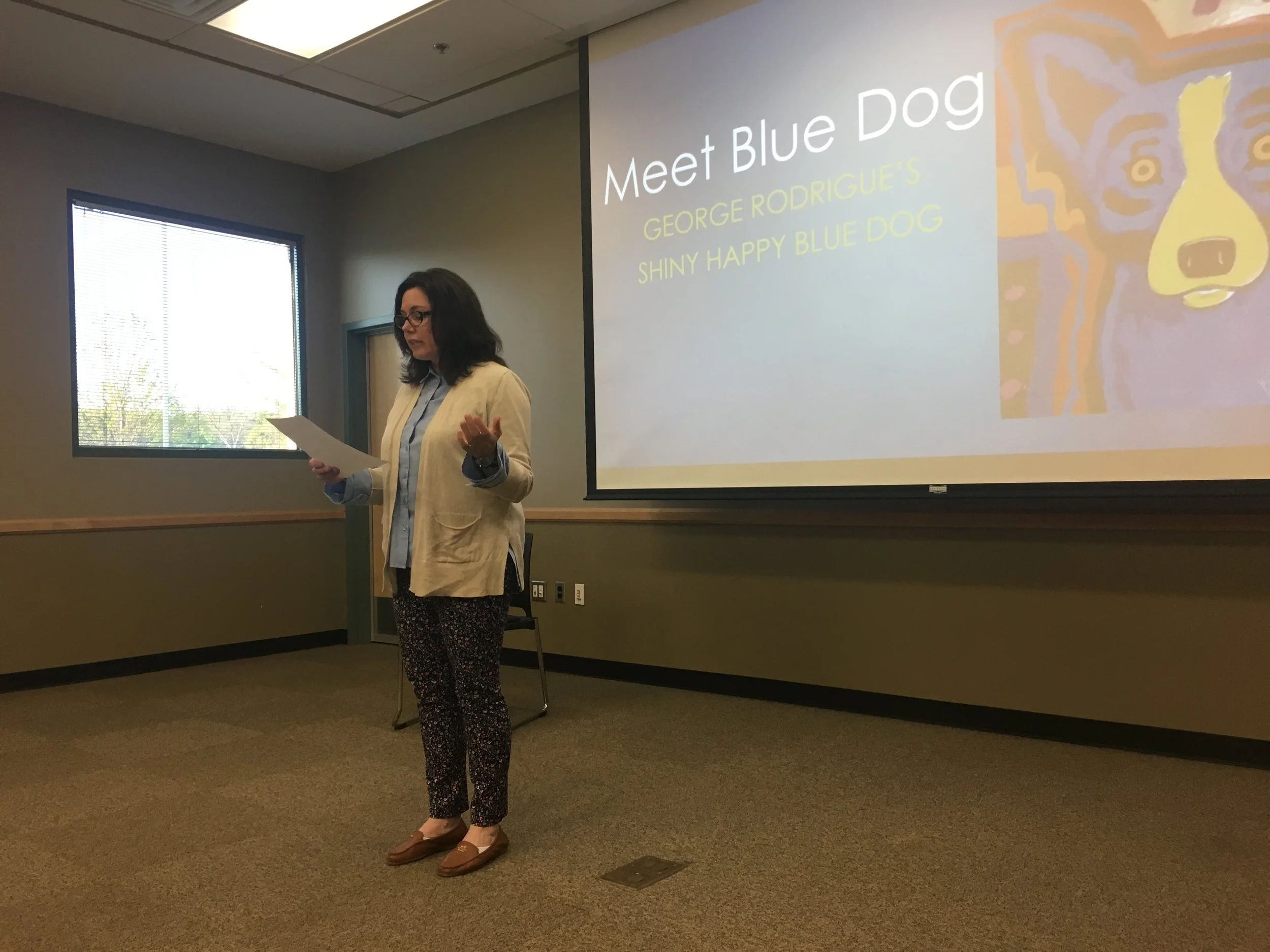  Julie Bedokis, owner of Dog and Duck Antiques in downtown Sand Springs, speaks at a publicity event for the Blue Dog exhibit, encouraging locals to get behind the campaign.  