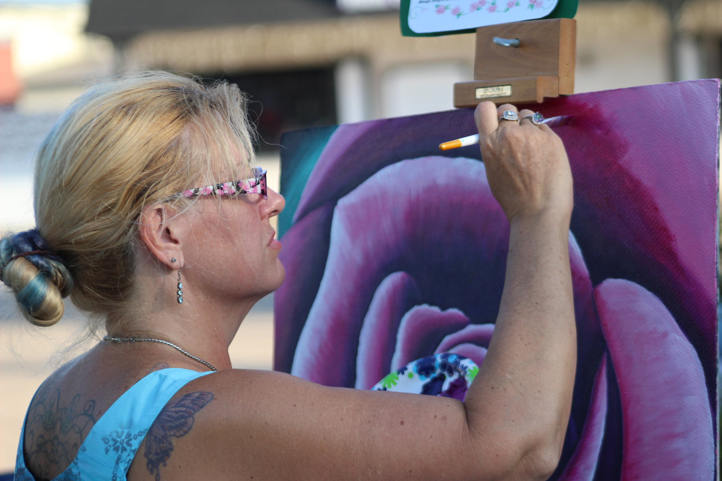  An artist from ZegART Studios paints a flower during the downtown concert. 