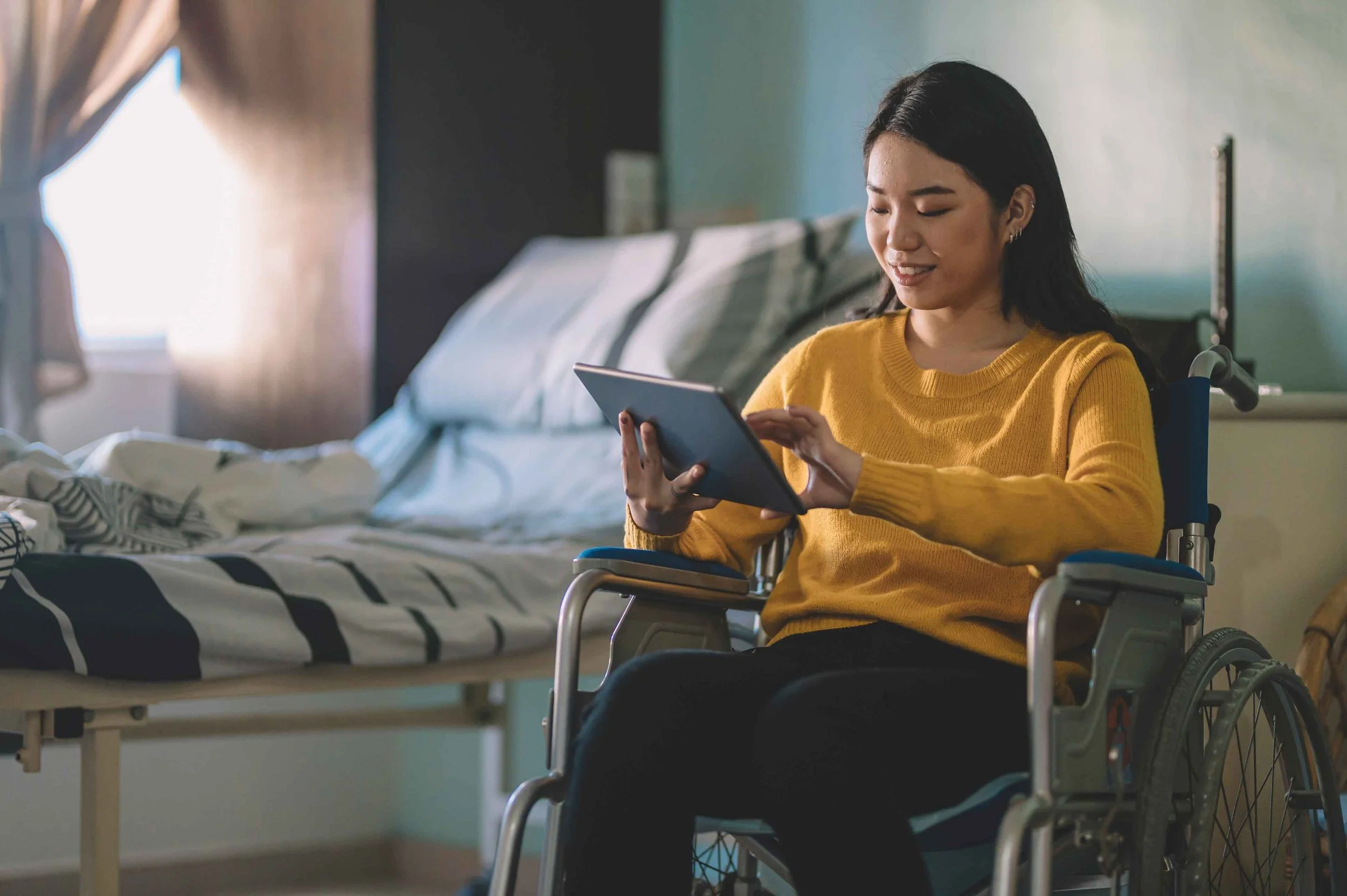 Female in the wheel chair looking at the table in the hospital ward.