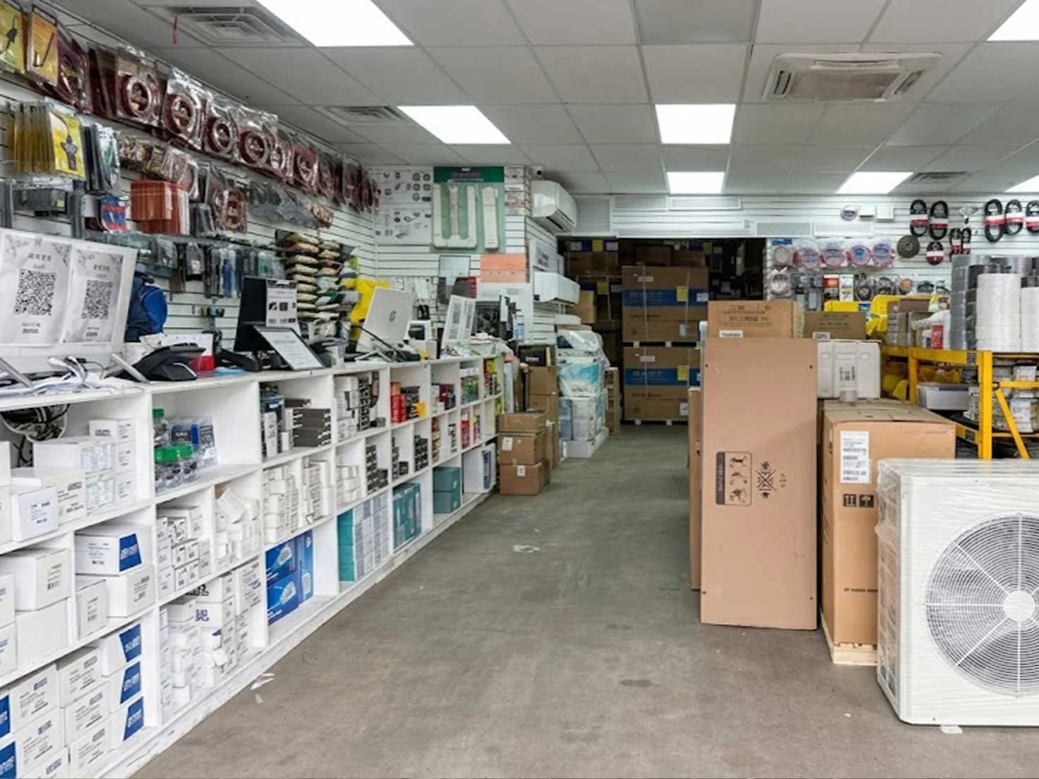 Professional view of the AC & Appliances Center interior with organized HVAC supplies, tools, and boxed units on display.