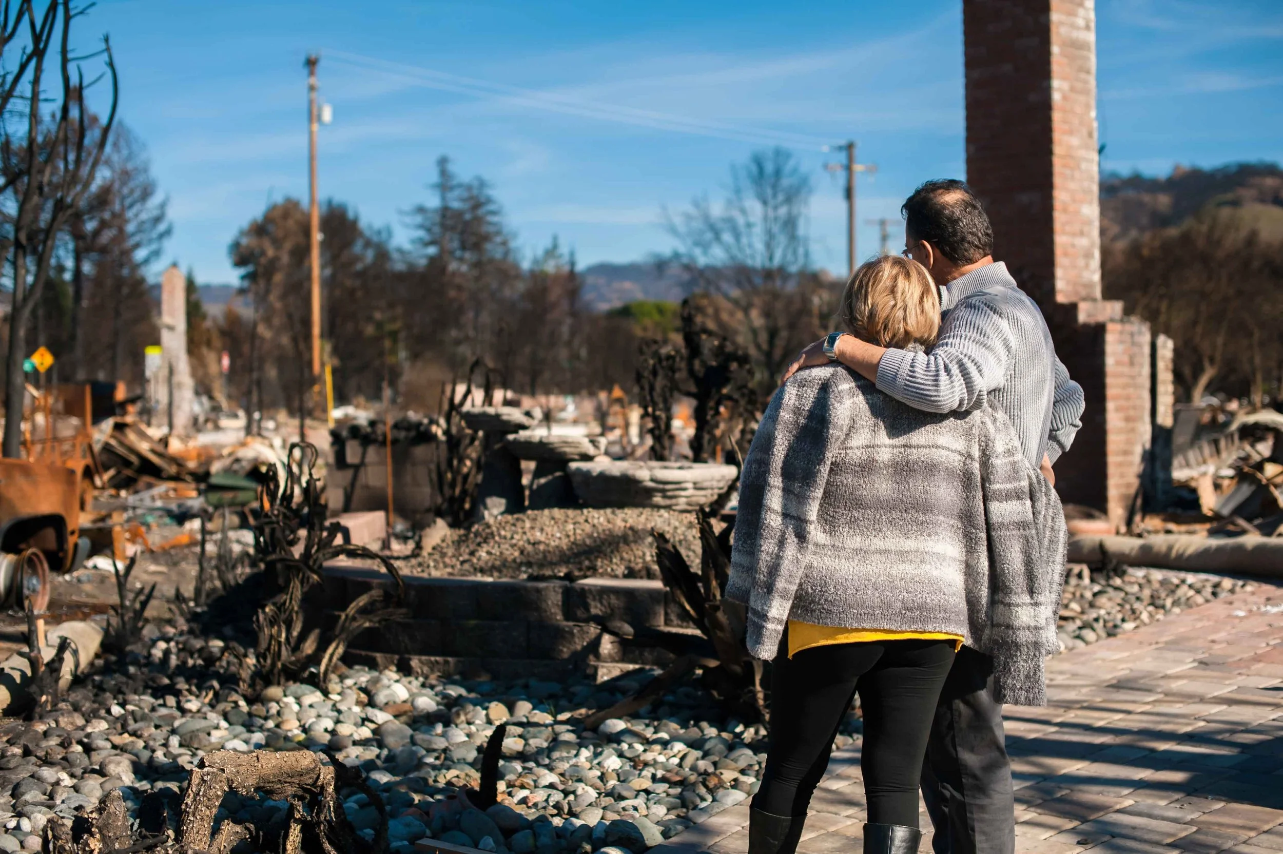 A couple looking at their ruined house.