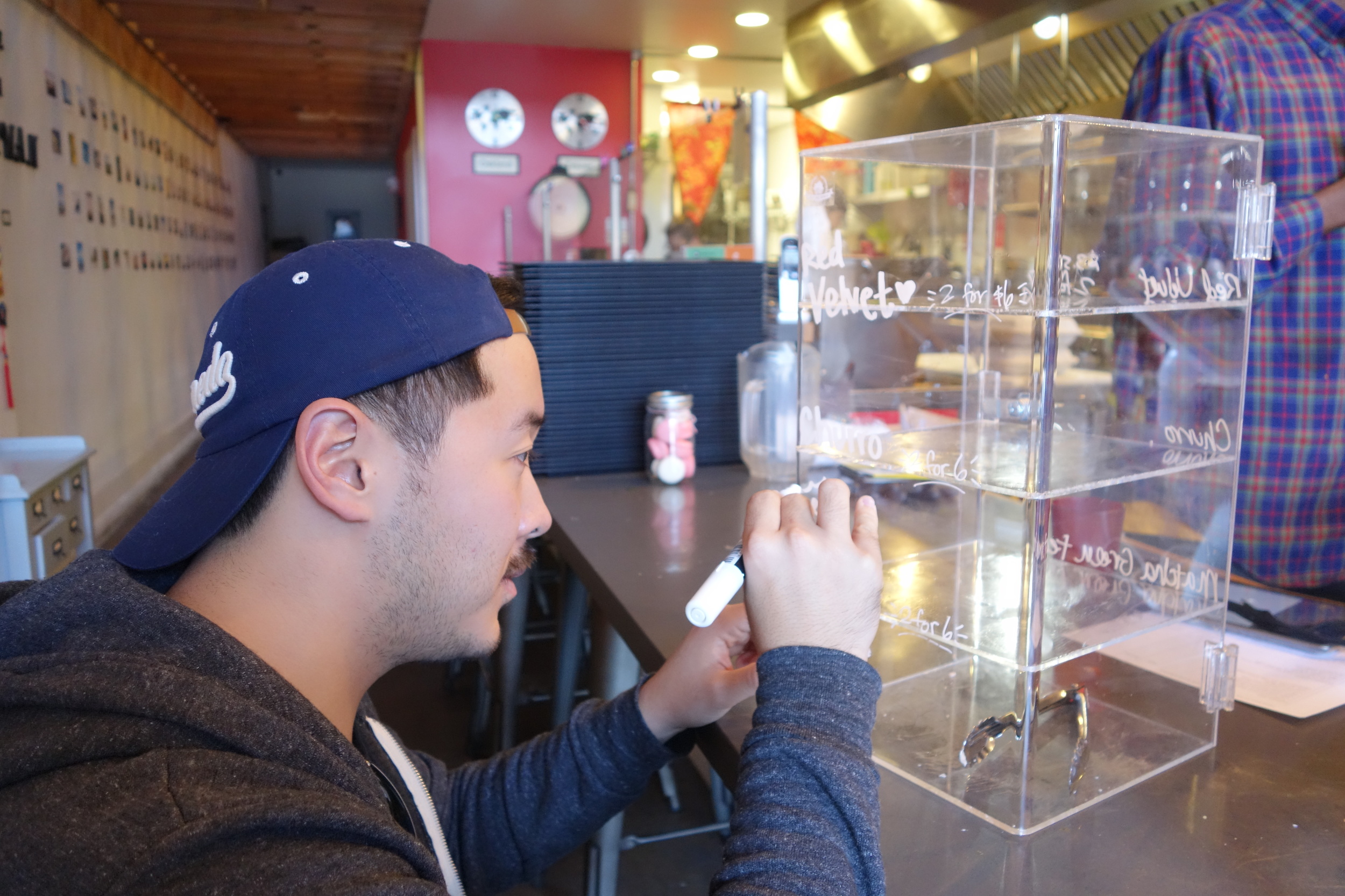 Wenter Shyu updates the flavors of the We The Minis's cupcake box stand at Taiwan Bento.