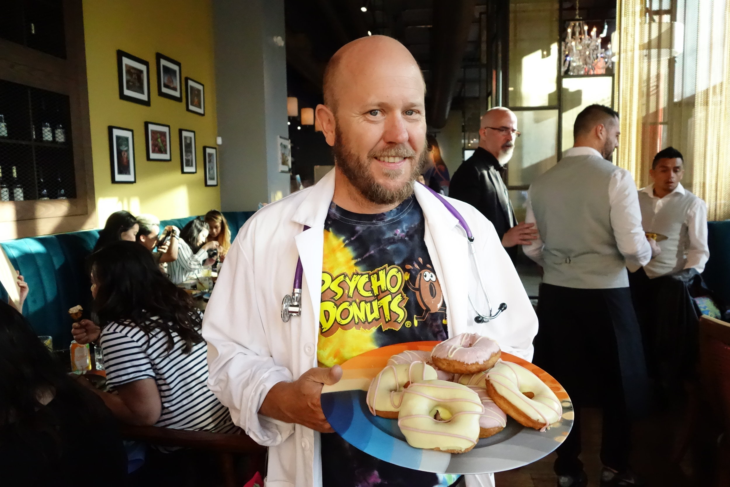 Psycho Donuts Owner Webster with custom-flavored glow-in-the-dark donuts made for Hansen's Supper Club, Presented by Foodbeast & Hansen's Sodas. Rooh SF, San Francisco, CA.