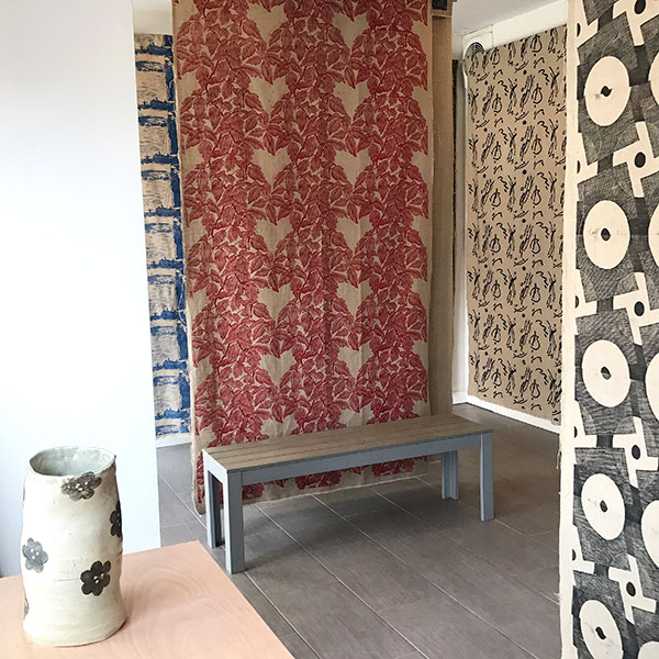 Installation of printed artist panels at Russell Janis gallery with a ceramic vessel by Janis Stemmermann on left