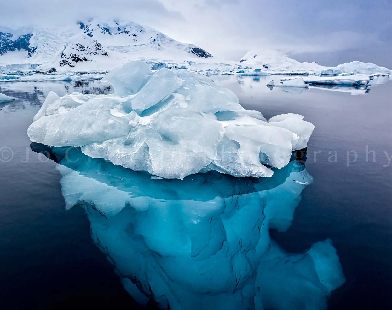 Small ice berg in clear, calm water showing torquoise ice underwater-Edit.jpg