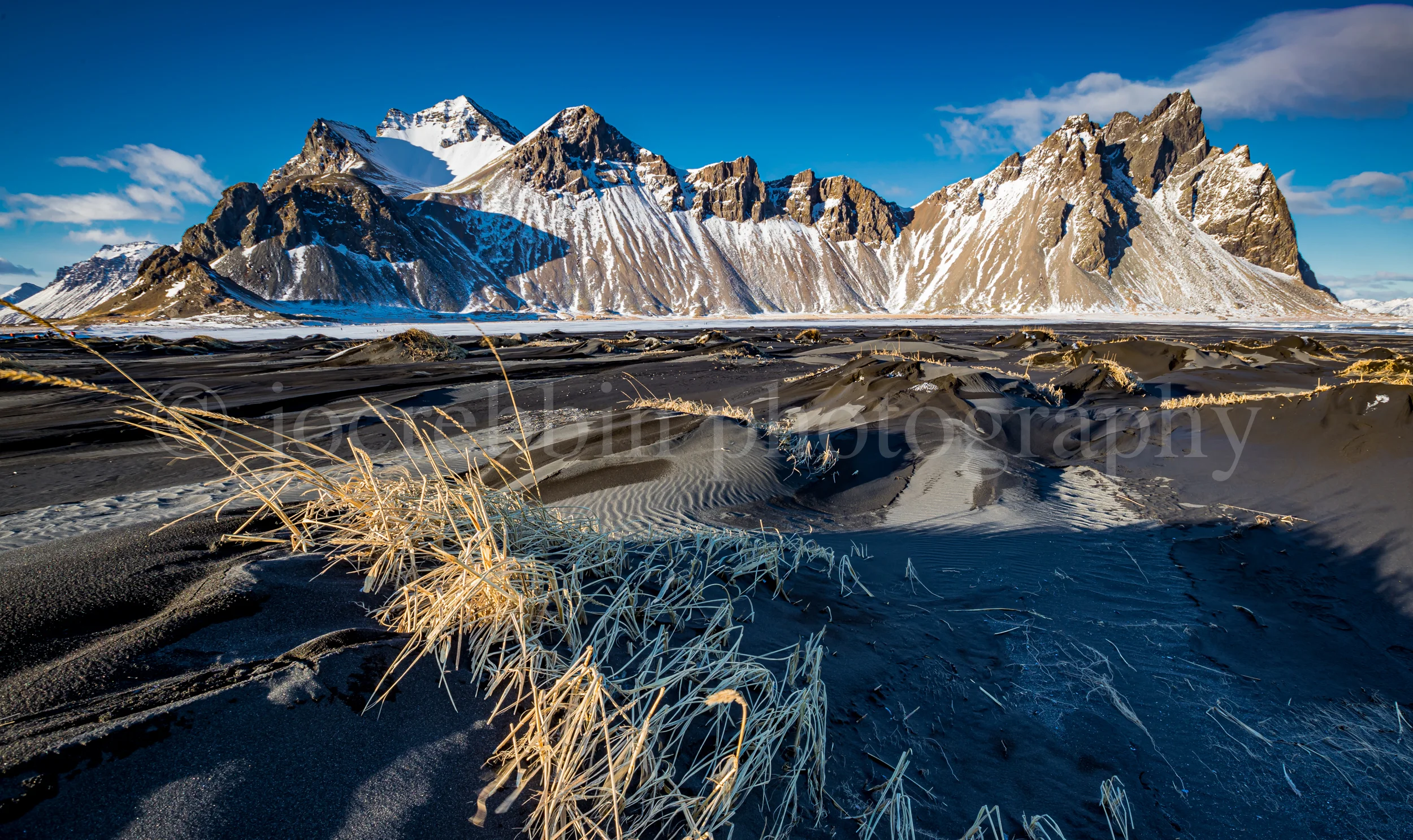 Dried, windswept grasses hang on to black sand hills in front of Vestrahorn_.jpg