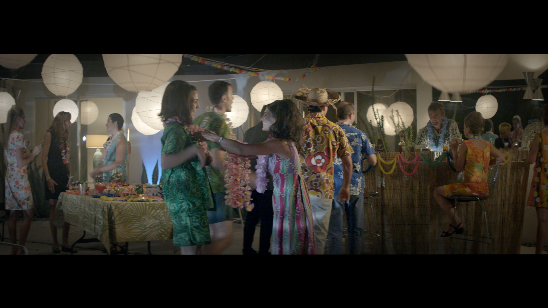 Audrey keeps up appearances, greeting guests at the housewarming luau party.