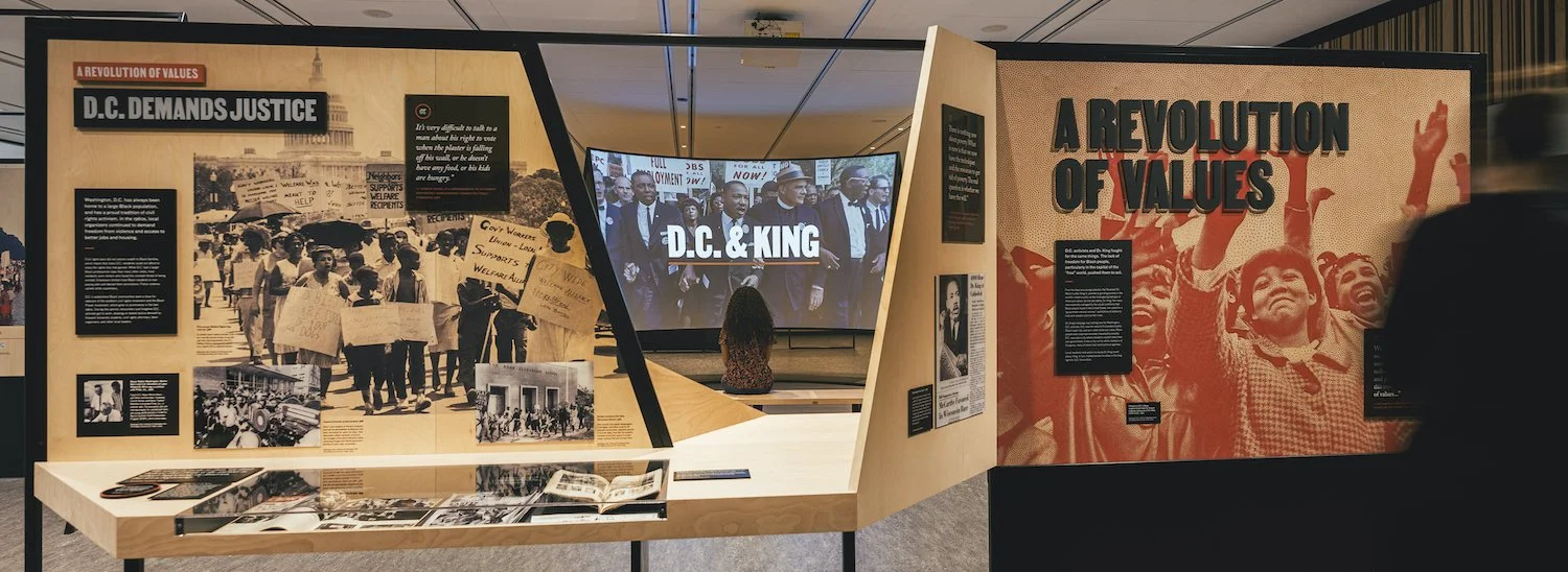 The curved screen, seen from across the gallery, showing the words "DC & King"