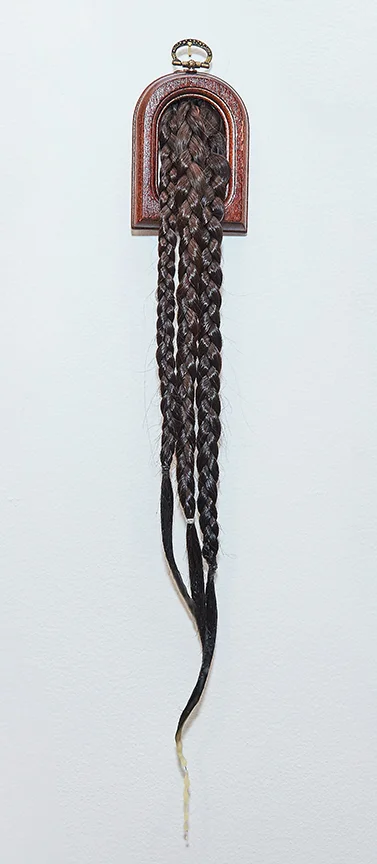 Three Braids , 2016 | Artist's own hair, beeswax and wooden frame | 18" x 3"