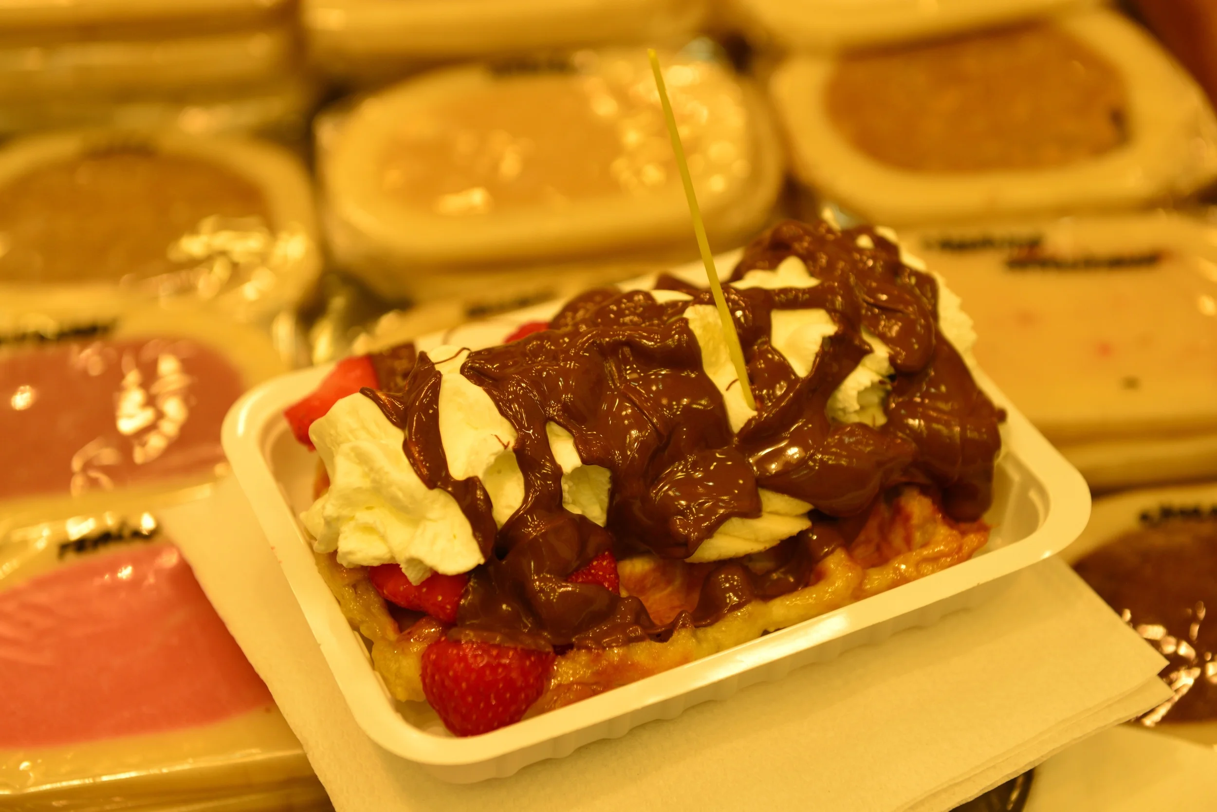 Sugar coated waffle with melted nutella, strawberries, bananas, and whipped cream. 